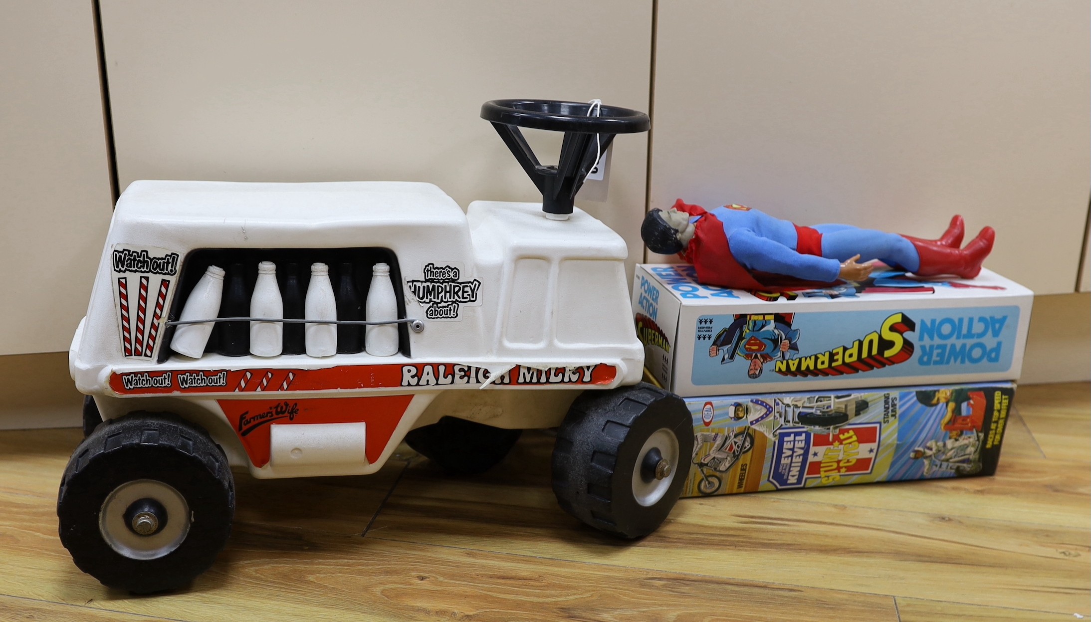 A Denys Fisher Superman, rare in original box, another unboxed, a Unigate milk float with bottles, and a boxed Evel Knievel Stunt Cycle